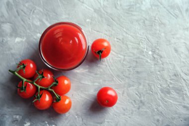 Kırmızı sos ve gri arka plan, üstten görünüm üzerinde kiraz domates ile kase