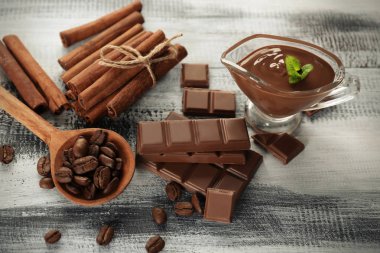 Lezzetli çikolata, tarçın ve ahşap zemin üzerine kahve çekirdekleri ile kompozisyon