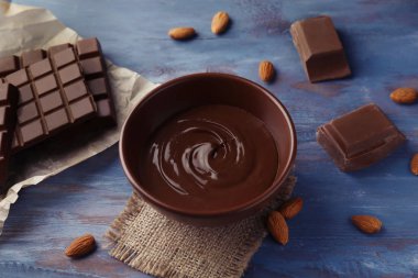 Ahşap masa üzerinde erimiş çikolata ile kase