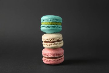 Koyu arka plan üzerinde lezzetli macarons yığını