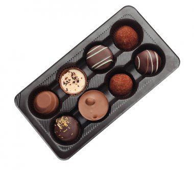 Beyaz arka planda lezzetli çikolata şekerleriyle dolu bir kutu.