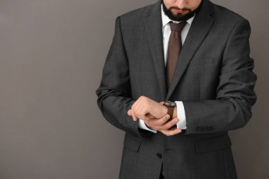 Onun gri arka plan üzerine bakarak adam. Zaman yönetimi kavramı