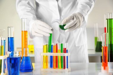 Laboratuar asistanı sıvı test tüpüne tablo üzerinden dökme.