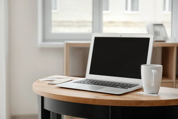 Стильне робоче місце з ноутбуком на столі — стокове фото
