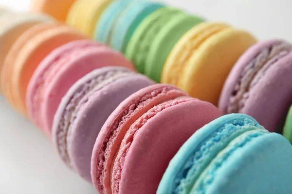 Sabrosos macarons coloridos sobre fondo blanco, primer plano — Foto de Stock