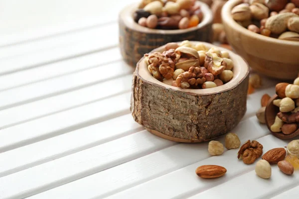 Миска з різними смачними горіхами на дерев'яному столі — стокове фото