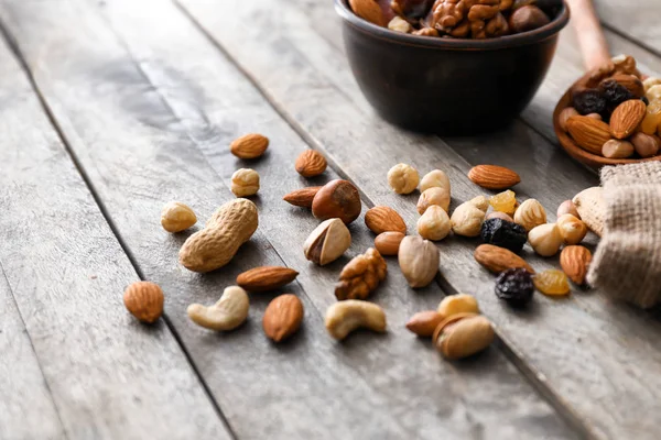 Различные вкусные орехи и сухофрукты на деревянном столе — стоковое фото