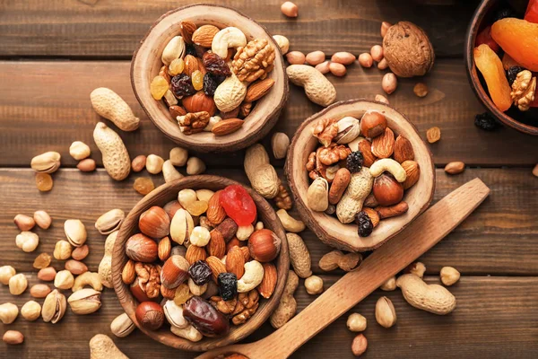 Cuencos con varios frutos secos sabrosos en la mesa de madera — Foto de Stock