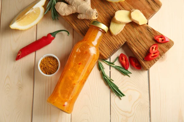 Komposition mit einer Flasche leckerer Sauce und Gemüse auf Holzgrund — Stockfoto