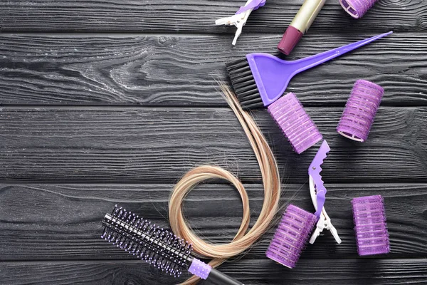 Composición plana con herramientas de peluquería y hebra de cabello rubio sobre fondo de madera —  Fotos de Stock