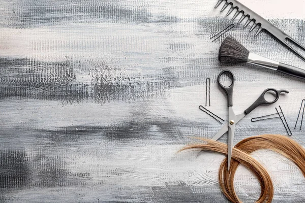 Flat lay composition with hairdresser's tools and strand of hair on wooden background — Stock Photo, Image