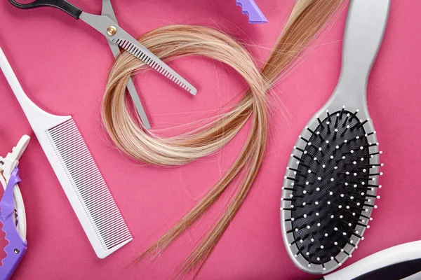Composición plana con herramientas de peluquería y hebra de cabello rubio sobre fondo de color —  Fotos de Stock