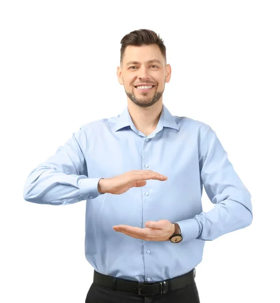 Joven empresario sosteniendo algo sobre fondo blanco — Foto de Stock