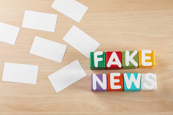 Phrase FAKE NEWS made from cubes with letters on wooden background — Stock Photo, Image