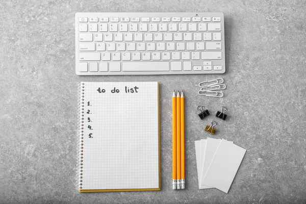 Lista de tareas vacías con papelería y teclado de computadora sobre fondo gris —  Fotos de Stock