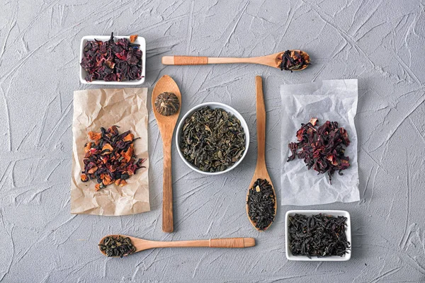 Plat lag samenstelling met verschillende soorten droge thee op grijze achtergrond — Stockfoto