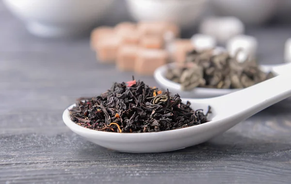 Keramiska sked med torr te på bordet — Stockfoto