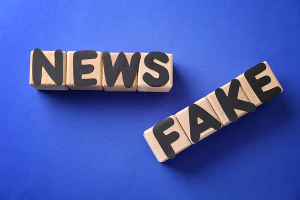 Testo FAKE NEWS fatto di cubi con lettere sullo sfondo a colori — Foto Stock