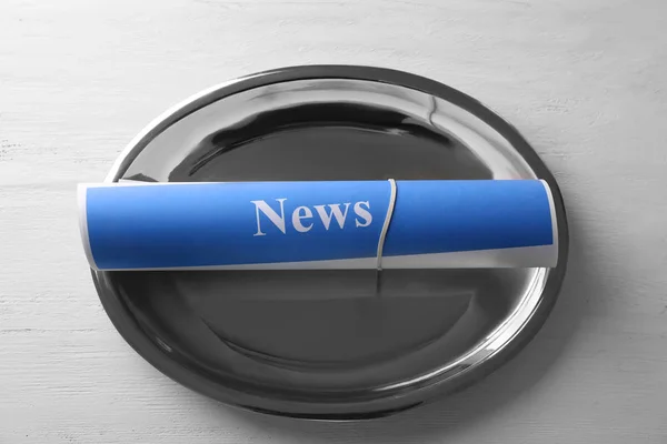 Roll of papers with word NEWS on metal tray — Stock Photo, Image