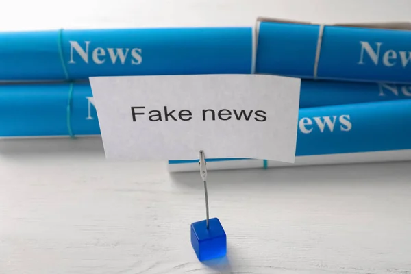 Papper med text falska nyheter på bord — Stockfoto