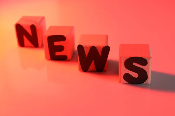 Word News aus Würfeln mit Buchstaben auf farbigem Hintergrund — Stockfoto
