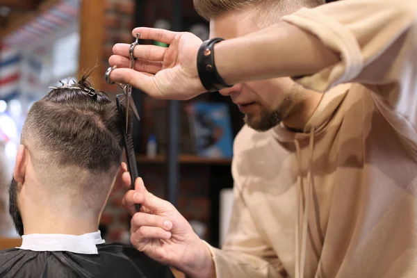 Barbier professionnel travaillant avec le client dans le salon de coiffure — Photo