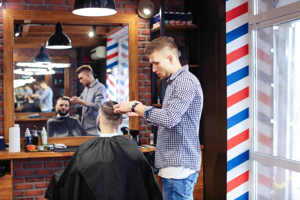 Barbier professionnel travaillant avec le client dans le salon de coiffure — Photo