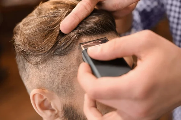 Barbeiro profissional trabalhando com o cliente no salão de cabeleireiro — Fotografia de Stock