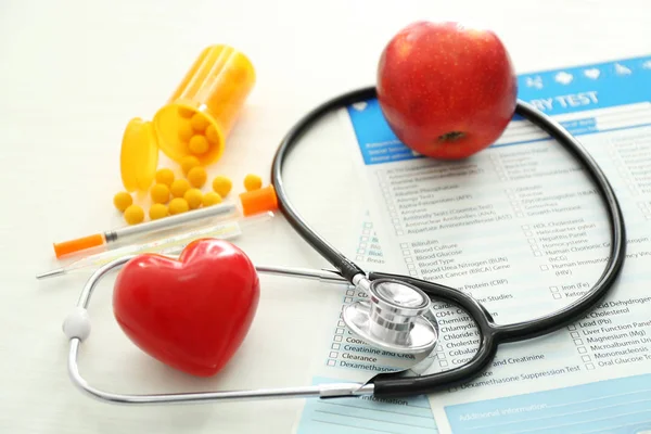 Stetoskop kırmızı kalp ve laboratuvar testleri beyaz arka plan üzerinde listeleri ile. Sağlık kavramı — Stok fotoğraf
