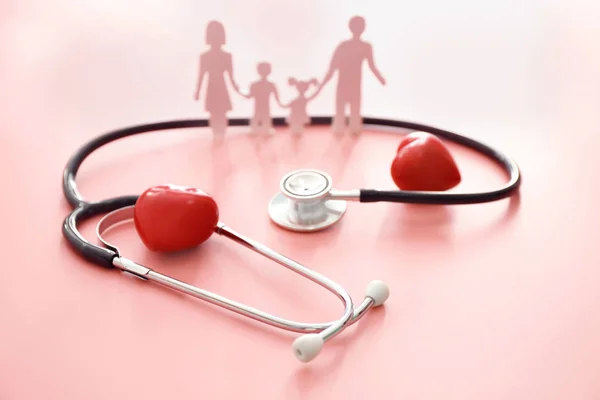Figura familiar, corazones rojos y estetoscopio sobre fondo de color. Concepto de salud — Foto de Stock