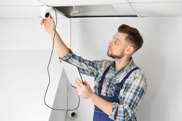 Electrician inspecting surveillance camera — Stock Photo, Image