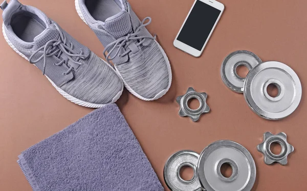 Flat lay composition with sneakers, weight plates and smartphone on color background. Gym workout — Stock Photo, Image