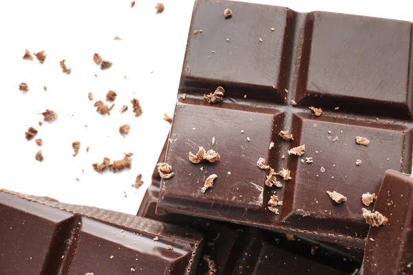 Bucăți de ciocolată neagră pe fundal alb, closeup — Fotografie, imagine de stoc