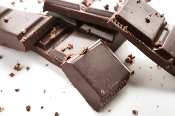 Pieces of dark chocolate on white background, closeup — Stock Photo, Image