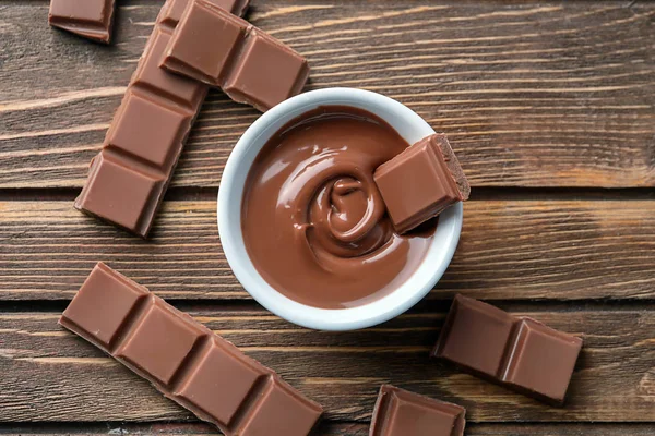 Composizione con gustoso cioccolato fuso su fondo in legno, vista dall'alto — Foto Stock