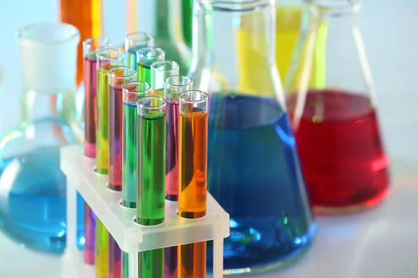 Test tubes with colorful liquids in rack, closeup — Stock Photo, Image