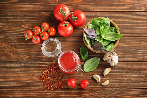 Köstliche rote Sauce im Glas und Zutaten auf dem Tisch, Draufsicht — Stockfoto