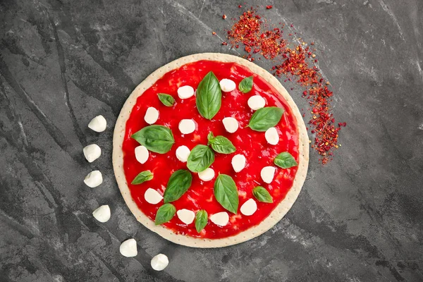 Pasta cruda per pizza con salsa rossa e ingredienti in tavola, vista dall'alto — Foto Stock