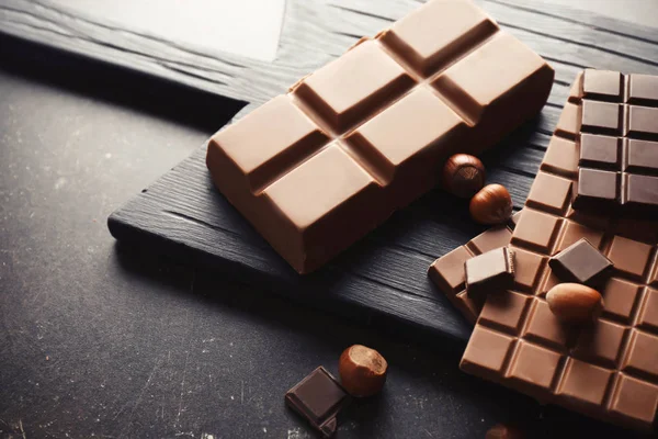 Sabroso chocolate y avellanas en la mesa — Foto de Stock