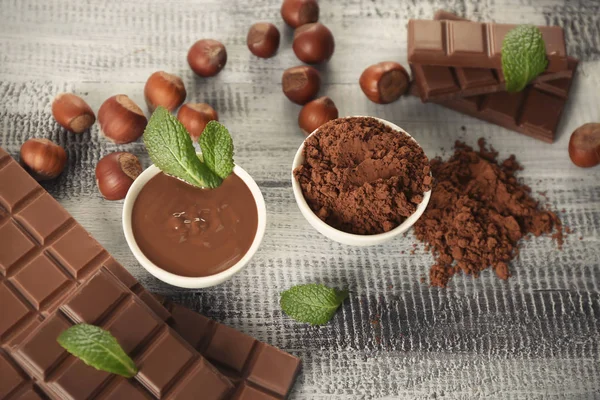 Composition avec savoureux chocolat et cacao en poudre sur table en bois — Photo