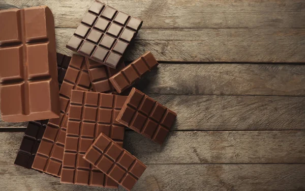 Sabroso chocolate sobre fondo de madera, vista superior — Foto de Stock