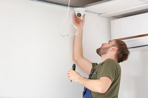 Eletricista instalando câmera de segurança dentro de casa — Fotografia de Stock