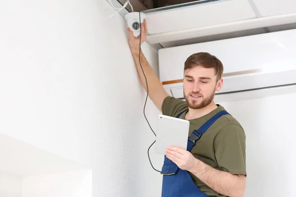 Eletricista instalando câmera de segurança dentro de casa — Fotografia de Stock