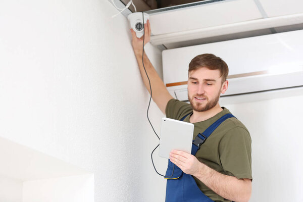 Electrician installing security camera indoors