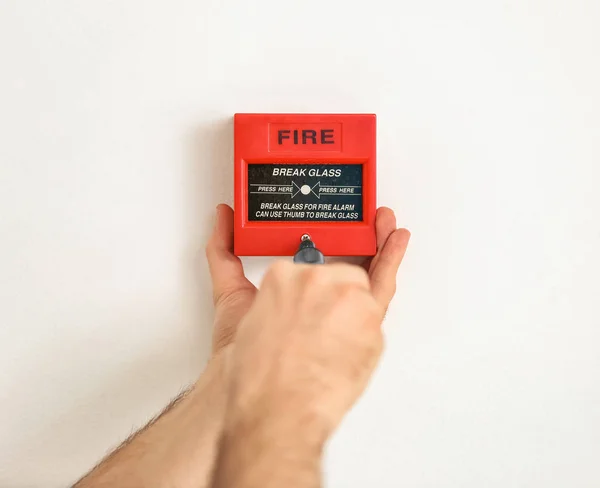 Электрик устанавливает пожарную сигнализацию на стену — стоковое фото