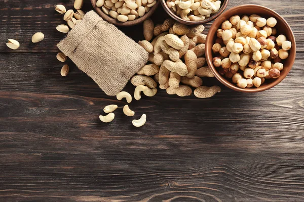 Composition with different nuts on wooden background — Stock Photo, Image