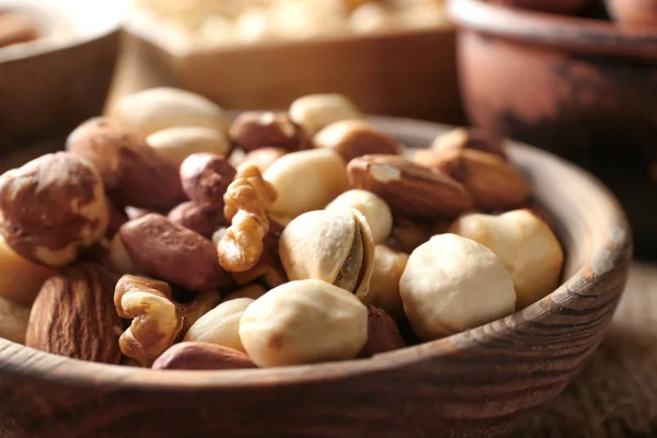 Diferentes nueces en cuenco de madera, primer plano — Foto de Stock