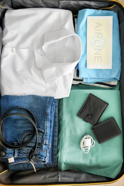Offener Koffer mit gepackten Sachen, Draufsicht — Stockfoto
