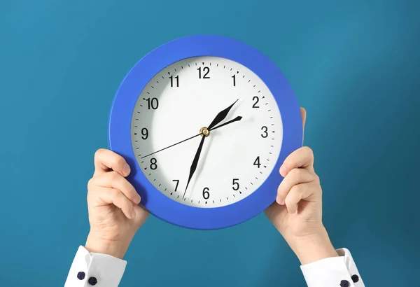 Man met klok op kleur achtergrond. Time management concept — Stockfoto