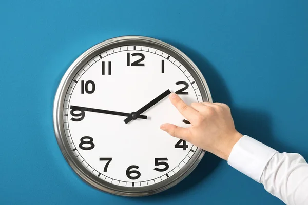 Człowiek, wskazując na zegarze przeciwko kolor tła. Koncepcja zarządzania czasu — Zdjęcie stockowe